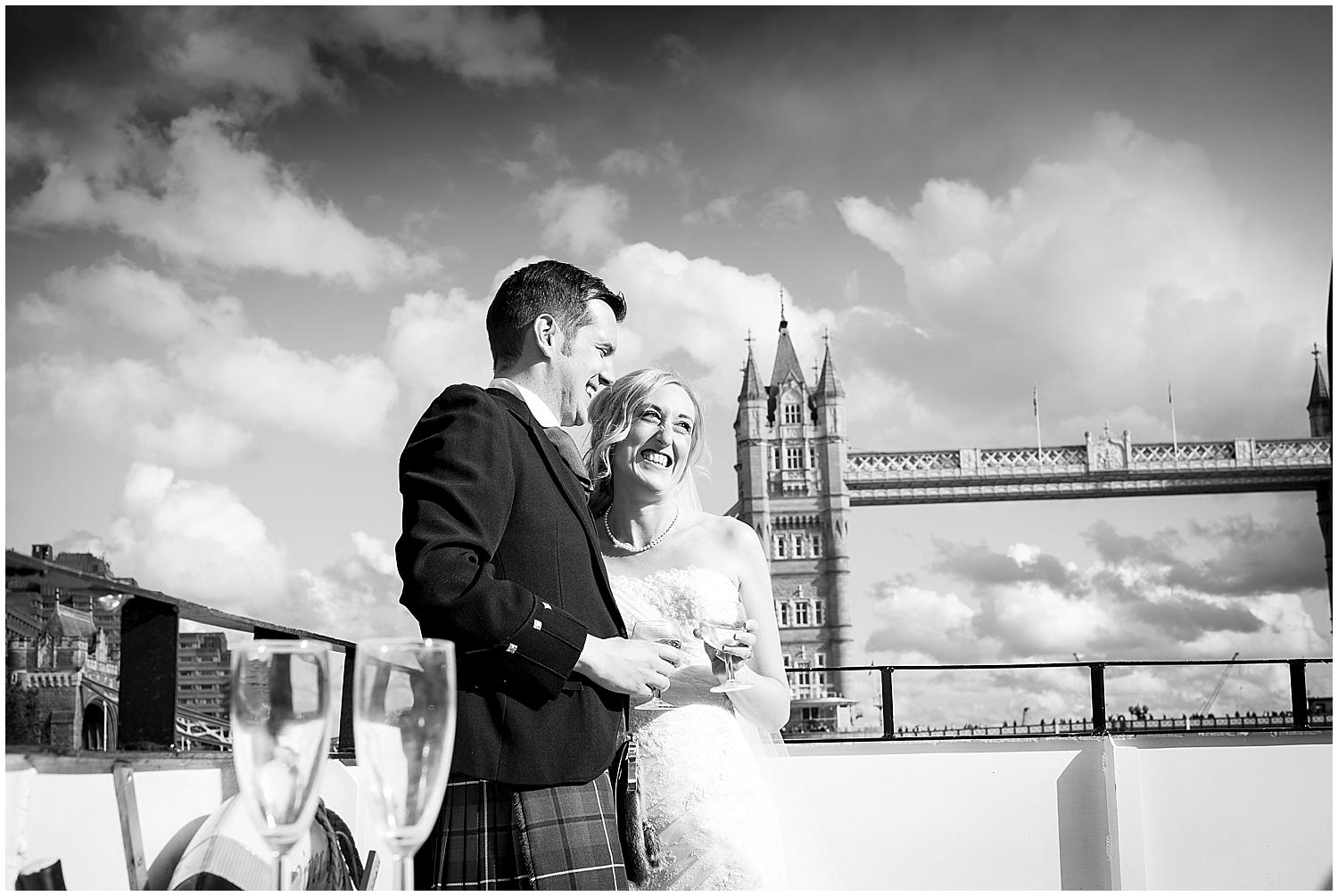 bride and groom getting married on boat on the thames beside tower of london