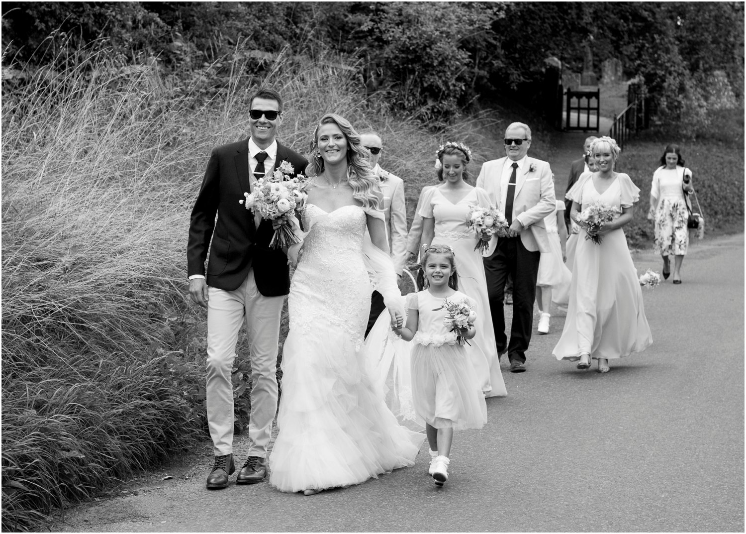 bride and groom in sunglasses walking to court lodge for wedding in the black barn